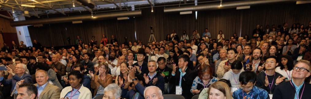 A packed room of founders applauding at the MIT AI Conference